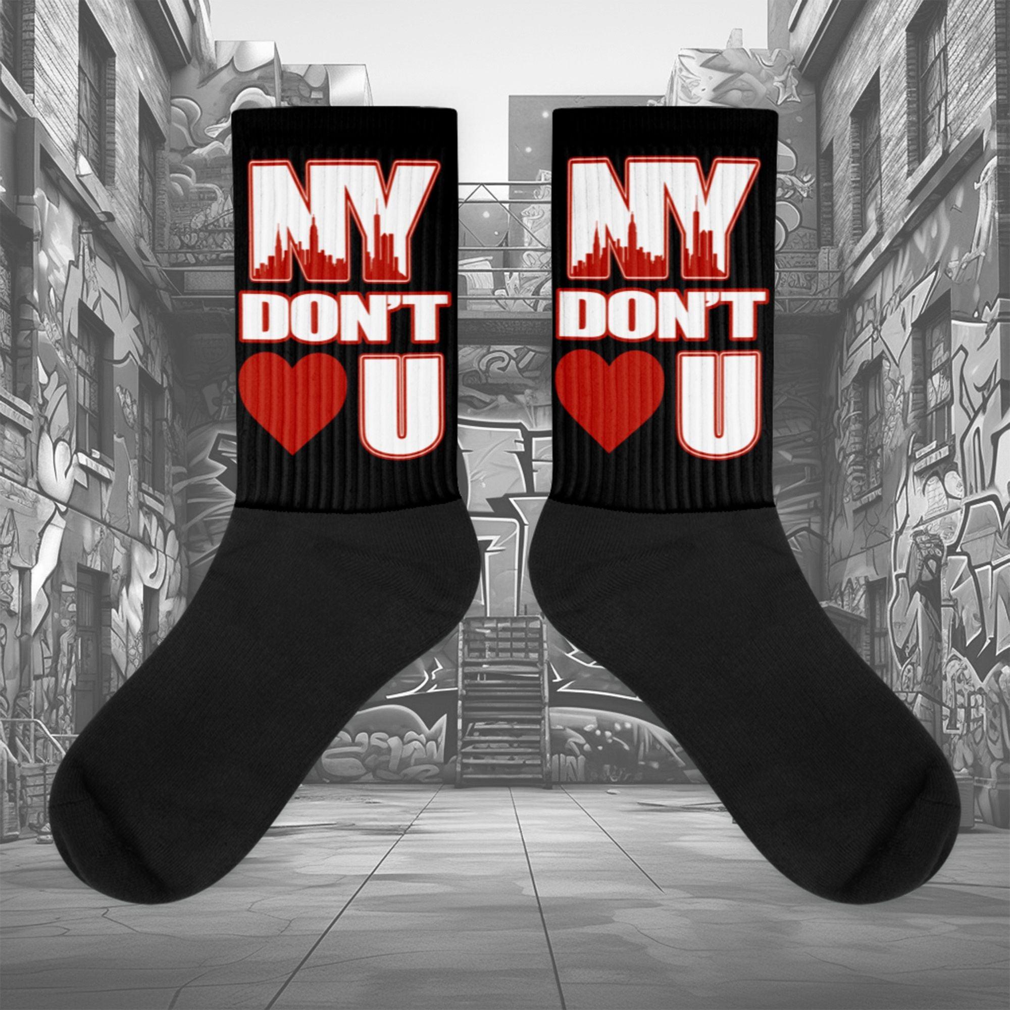 Showcases the view of the socks, highlighting the vibrant ' NY Don’t Love U ' design, which perfectly complements the Air Jordan 11 Cherry sneakers. The intricate pattern and color scheme inspired by the  theme are prominently displayed.  Focusing on the ribbed leg , cusioned bottoms and the snug fit of the socks. This angle provides a clear view of the texture and quality of the material blend.