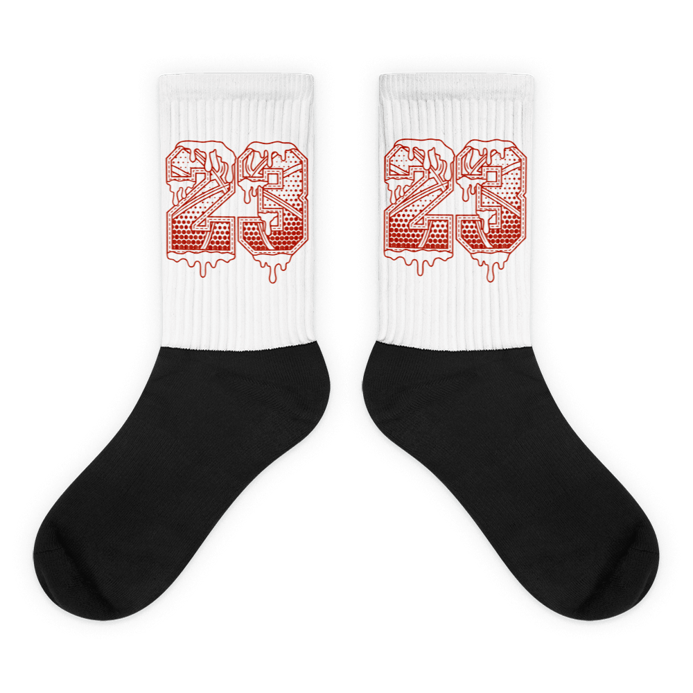 Showcases the view of the socks, highlighting the vibrant ' 23 Ball ' design, which perfectly complements the Air Jordan 11 Cherry sneakers. The intricate pattern and color scheme inspired by the  theme are prominently displayed.  Focusing on the ribbed leg , cusioned bottoms and the snug fit of the socks. This angle provides a clear view of the texture and quality of the material blend