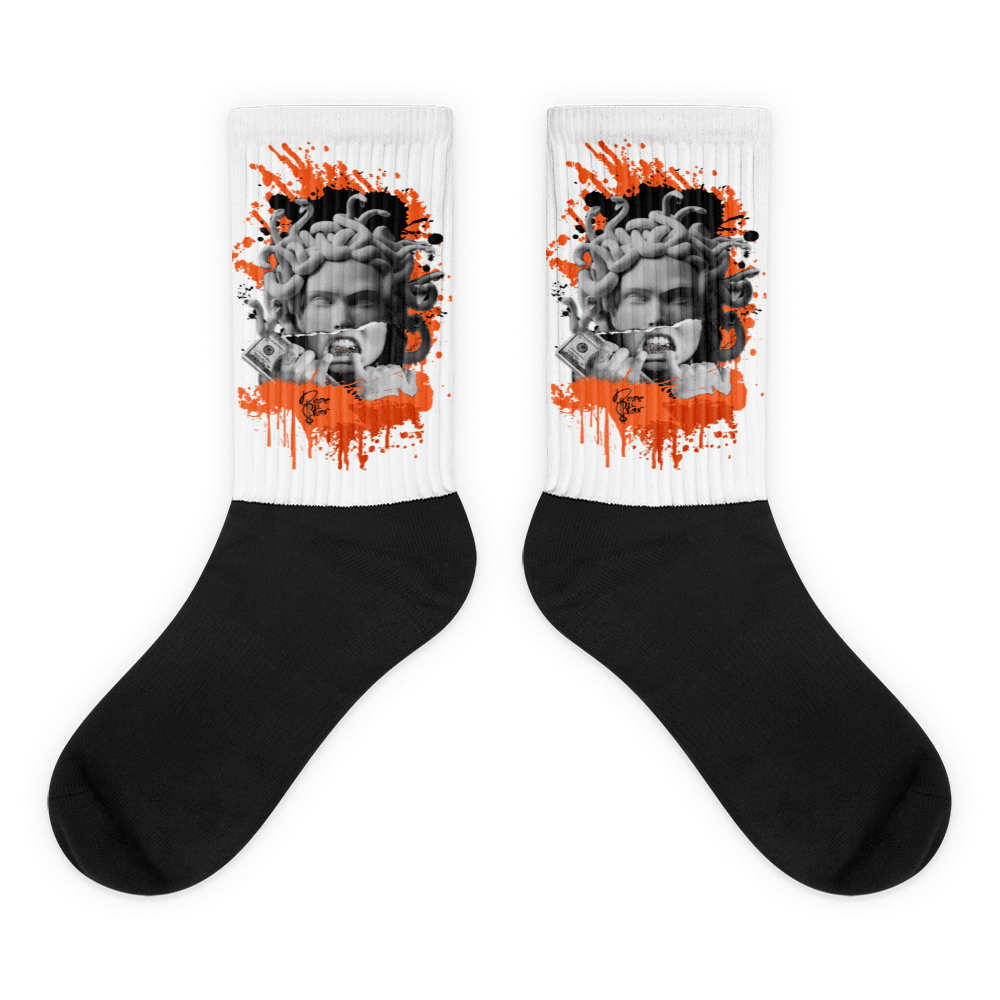 Showcases the view of the socks, highlighting the vibrant ' MEDUSA' design, which perfectly complements the Air Jordan 12 Retro WNBA All-Star Brilliant Orange sneakers. The intricate pattern and color scheme inspired by the  theme are prominently displayed.  Focusing on the ribbed leg , cusioned bottoms and the snug fit of the socks. This angle provides a clear view of the texture and quality of the material blend.