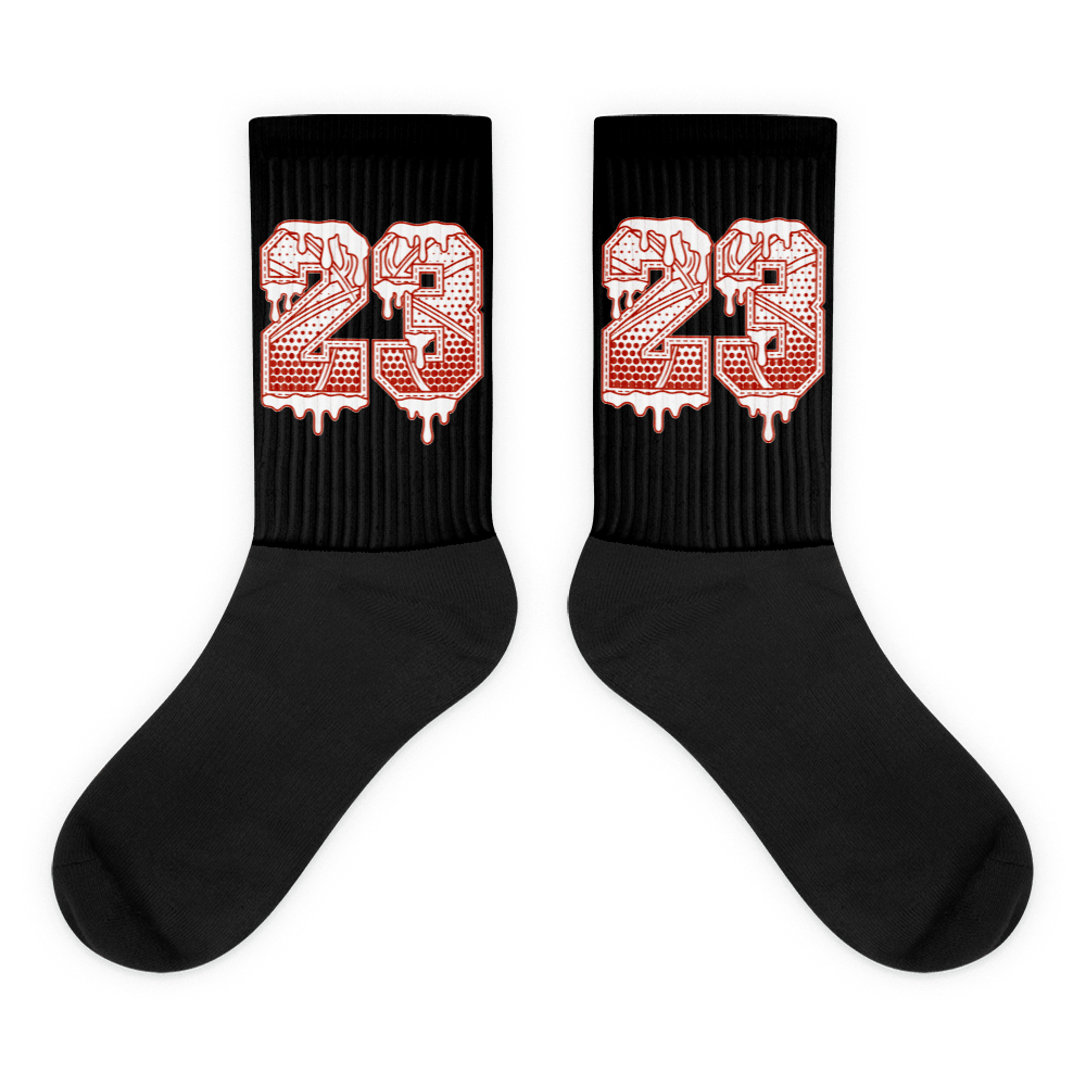 Showcases the view of the socks, highlighting the vibrant ' 23 Ball ' design, which perfectly complements the Air Jordan 11 Cherry sneakers. The intricate pattern and color scheme inspired by the  theme are prominently displayed.  Focusing on the ribbed leg , cusioned bottoms and the snug fit of the socks. This angle provides a clear view of the texture and quality of the material blend