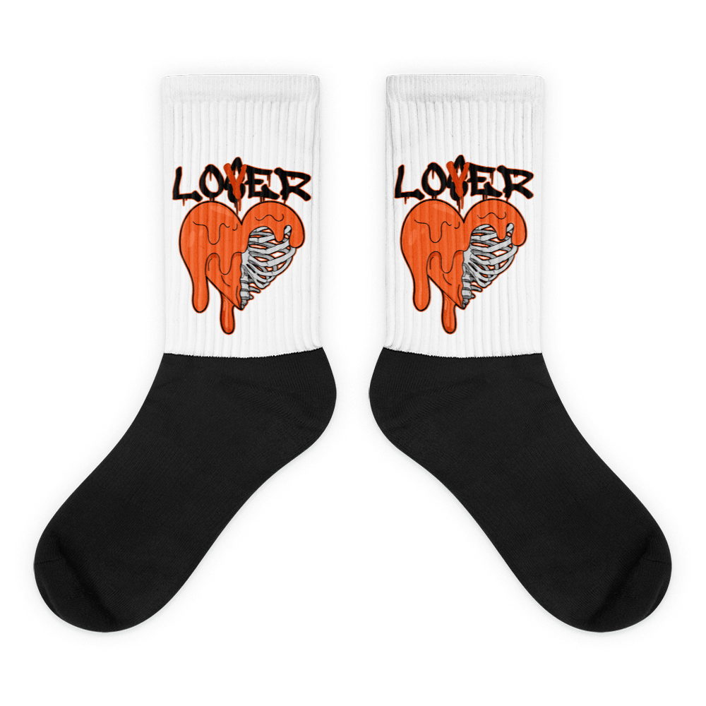 Showcases the view of the socks, highlighting the vibrant ' Lover Loser ‘ design, which perfectly complements the Air Jordan 12 Retro WNBA All-Star Brilliant Orange sneakers. The intricate pattern and color scheme inspired by the  theme are prominently displayed.  Focusing on the ribbed leg , cusioned bottoms and the snug fit of the socks. This angle provides a clear view of the texture and quality of the material blend.