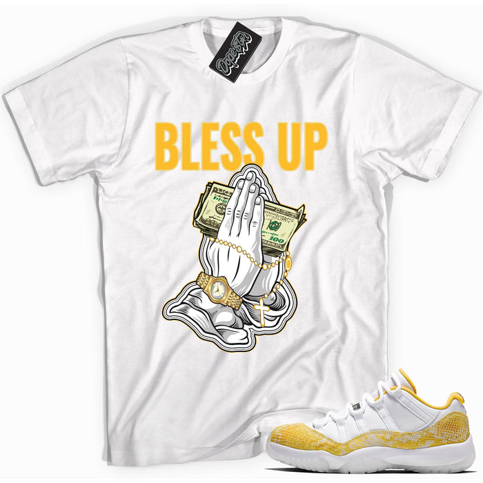 Cool white graphic tee with 'bless up' print, that perfectly matches Air Jordan 11 Retro Low Yellow Snakeskin sneakers