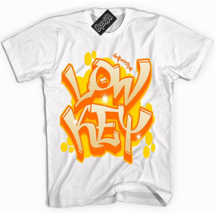 White “Low Key” T-shirt by Dope Star Brand®, styled to match Saturn Gold Dunk sneakers.